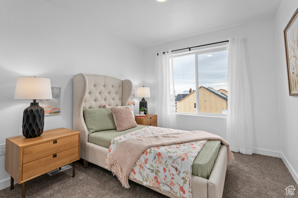 Carpeted bedroom featuring baseboards and visible vents