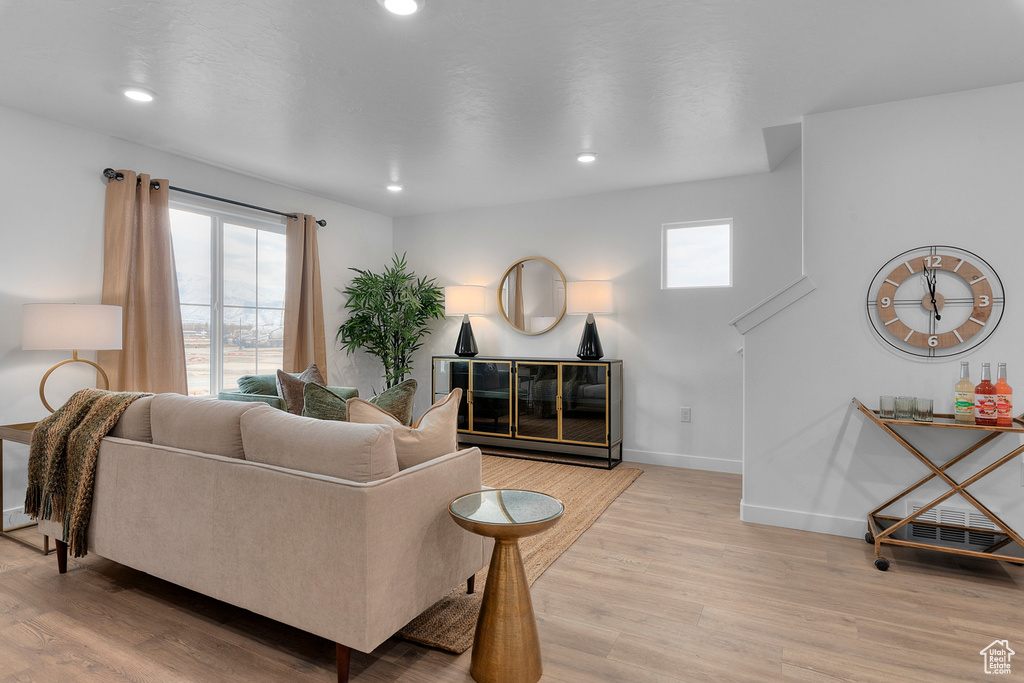 Living area featuring baseboards, light wood-style flooring, and a wealth of natural light