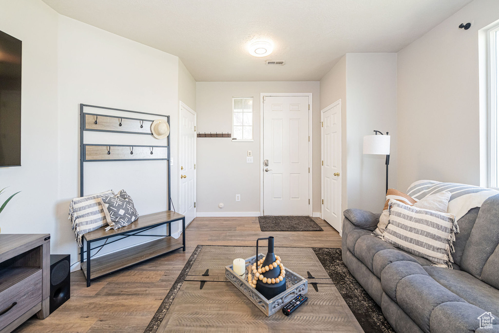 Living room with baseboards, visible vents, and wood finished floors