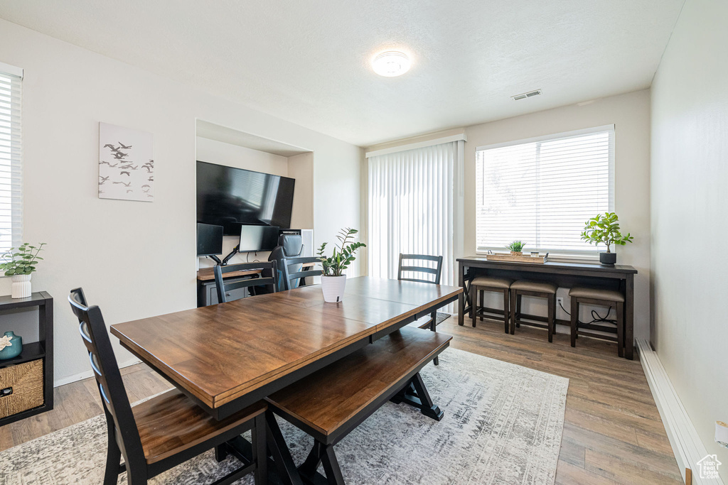 Dining area with baseboards, visible vents, and wood finished floors