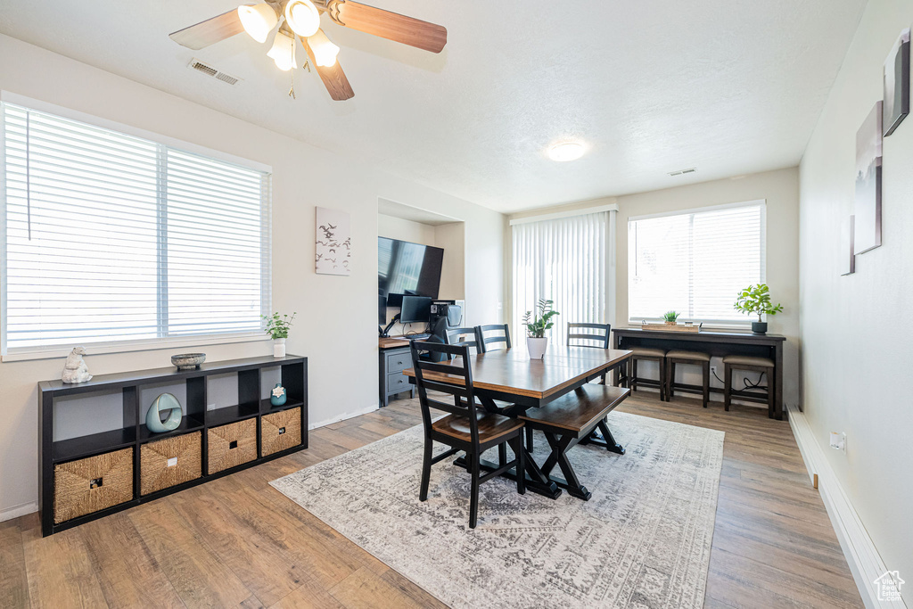 Dining room with visible vents, baseboards, ceiling fan, and wood finished floors
