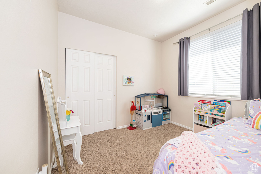 Carpeted bedroom with baseboards and a closet