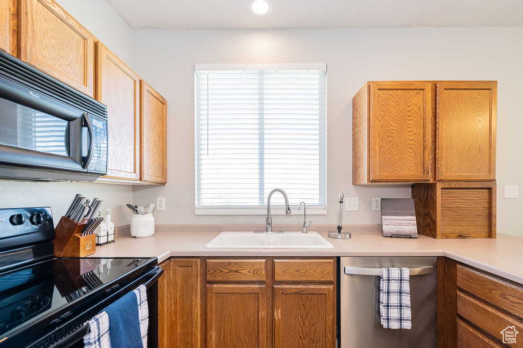 Kitchen with light countertops, recessed lighting, a sink, and black appliances