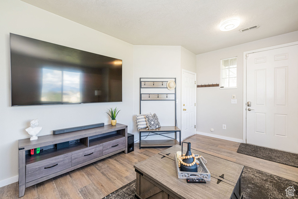 Living area featuring baseboards, wood finished floors, and visible vents