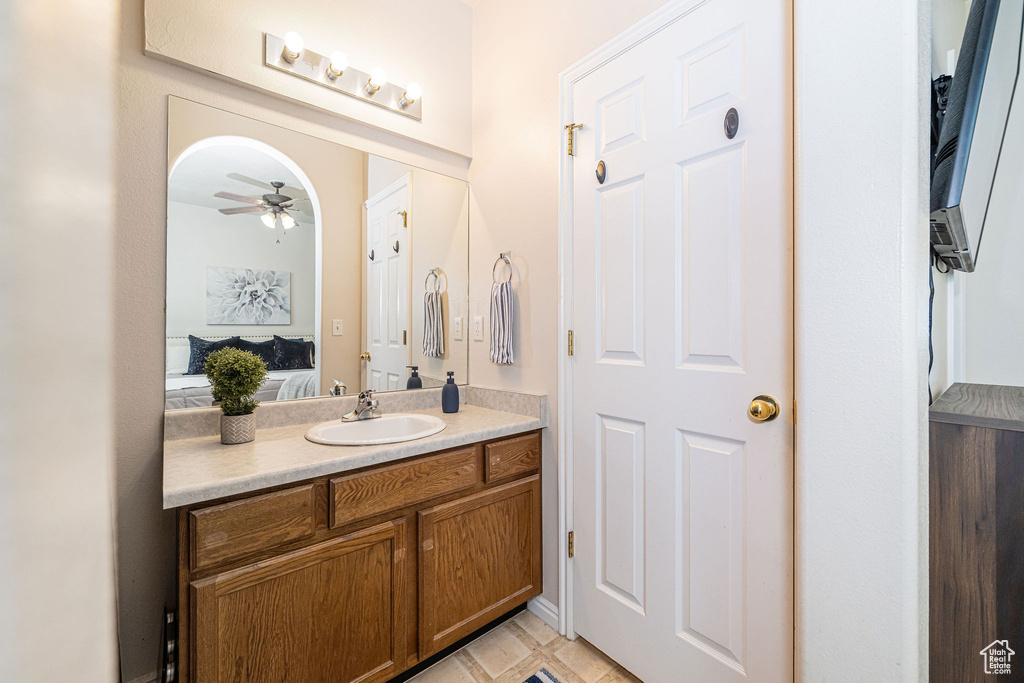 Ensuite bathroom featuring vanity, a ceiling fan, tile patterned floors, and connected bathroom