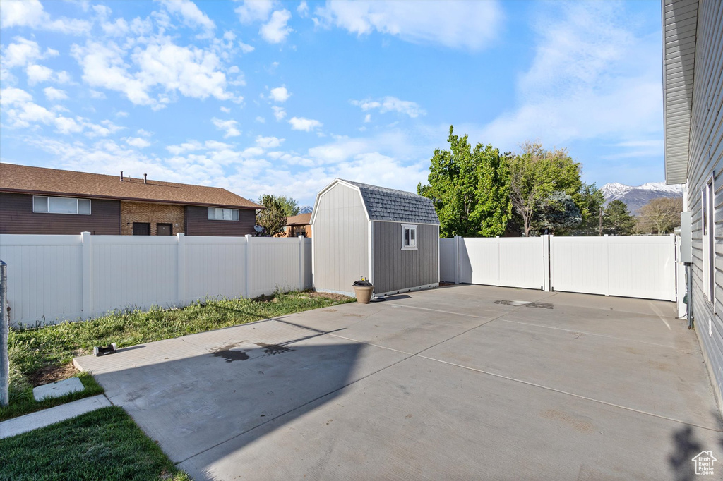 View of patio / terrace with an outdoor structure, a fenced backyard, and a storage unit