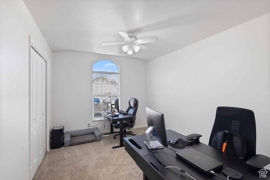 Carpeted office space with a ceiling fan