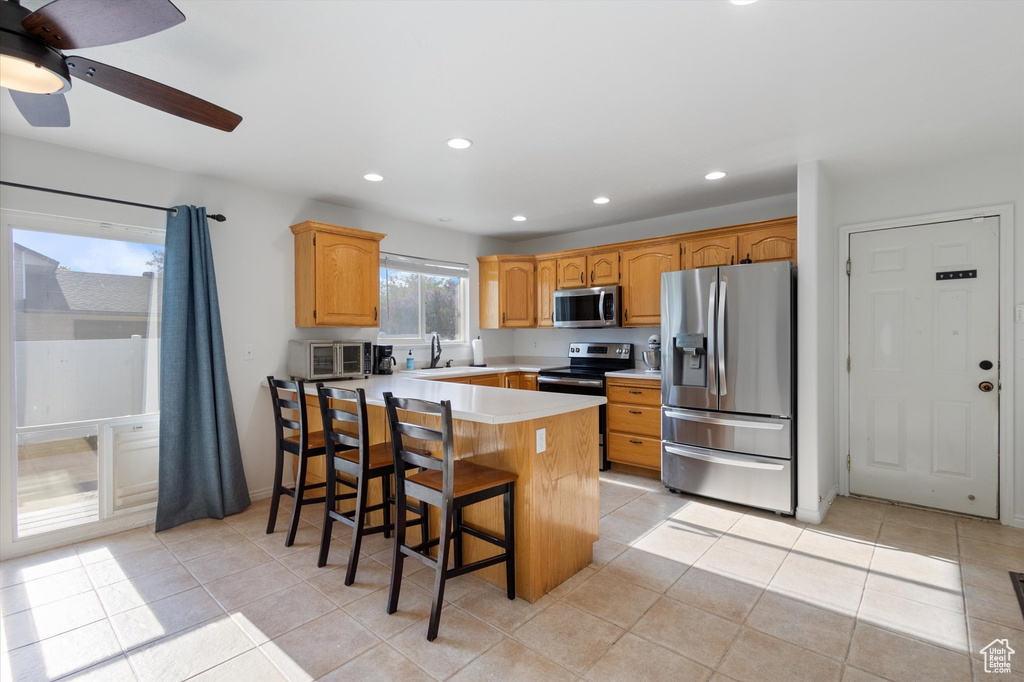 Kitchen with a sink, light countertops, stainless steel appliances, recessed lighting, and a peninsula