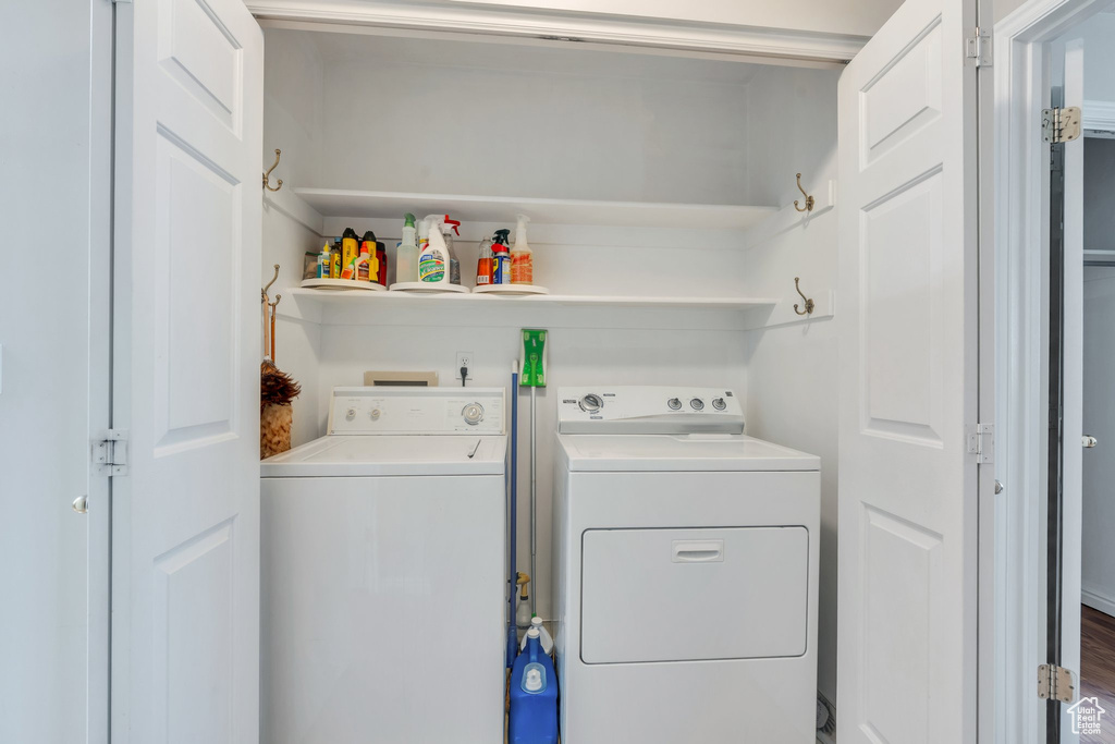 Laundry area with wood finished floors, laundry area, and independent washer and dryer