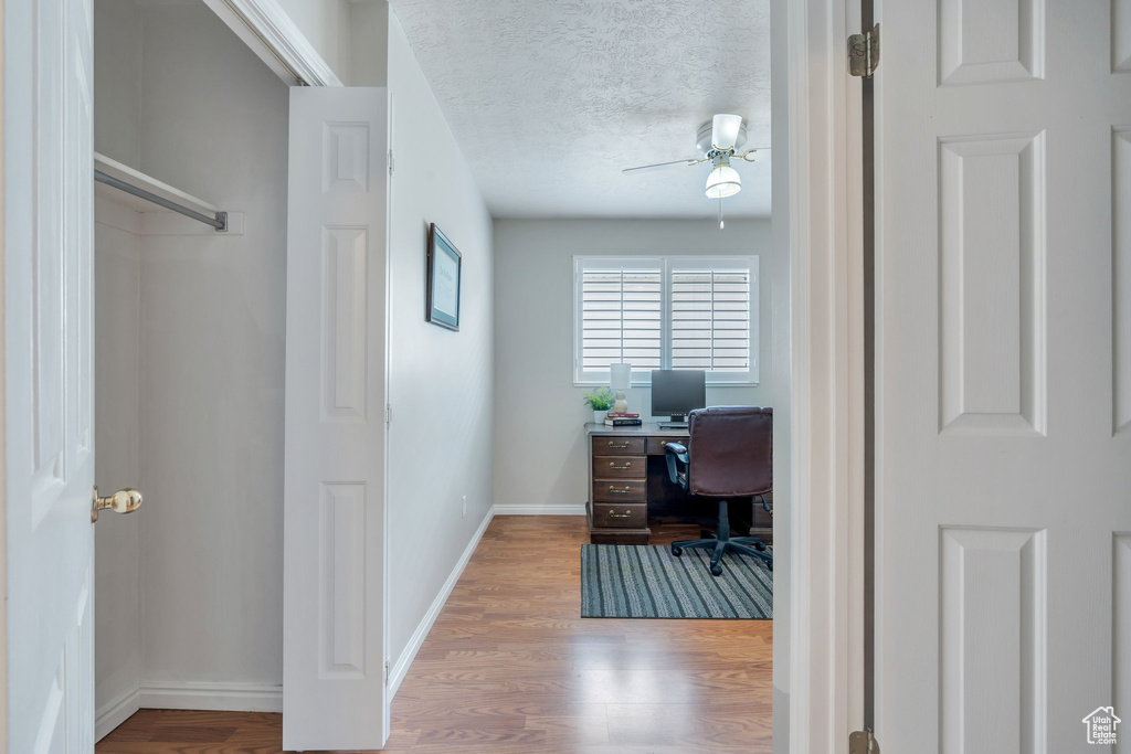 Office space featuring wood finished floors, a textured ceiling, baseboards, and ceiling fan