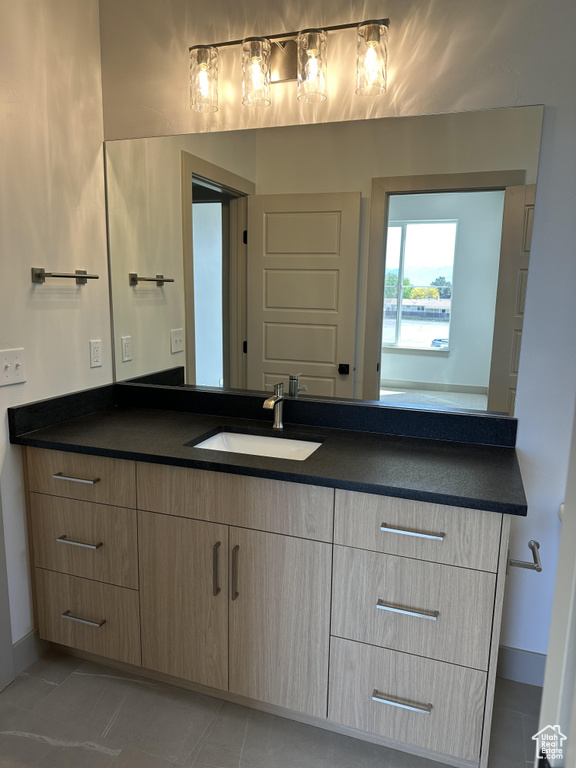 Bathroom featuring vanity, baseboards, and tile patterned floors