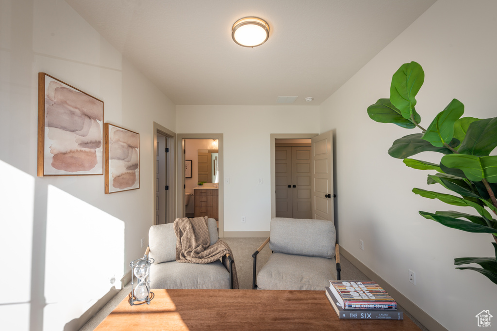 Sitting room with baseboards and carpet flooring