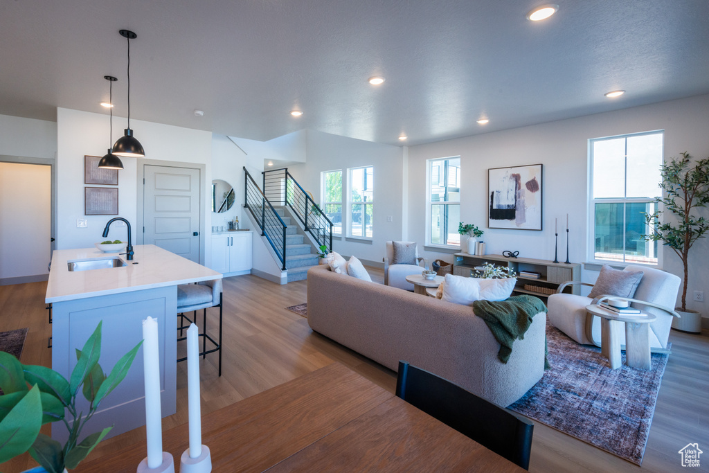Living area featuring recessed lighting, light wood finished floors, a wealth of natural light, and stairway