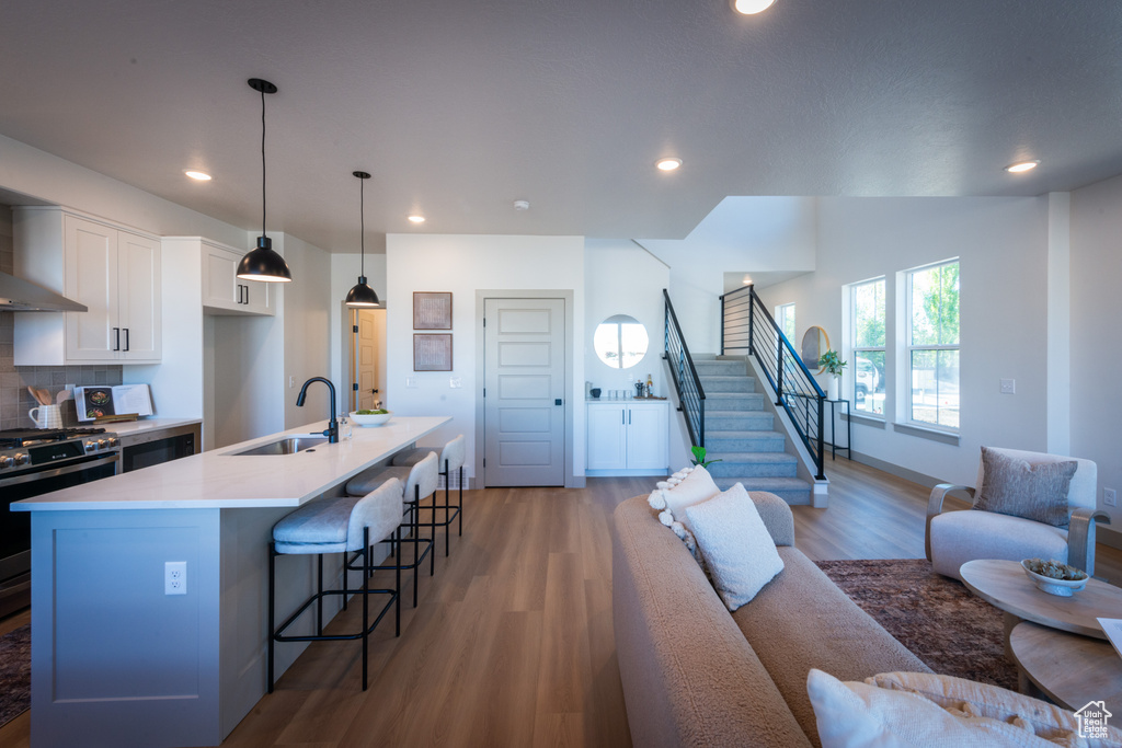 Living room featuring stairway, recessed lighting, baseboards, and light wood finished floors
