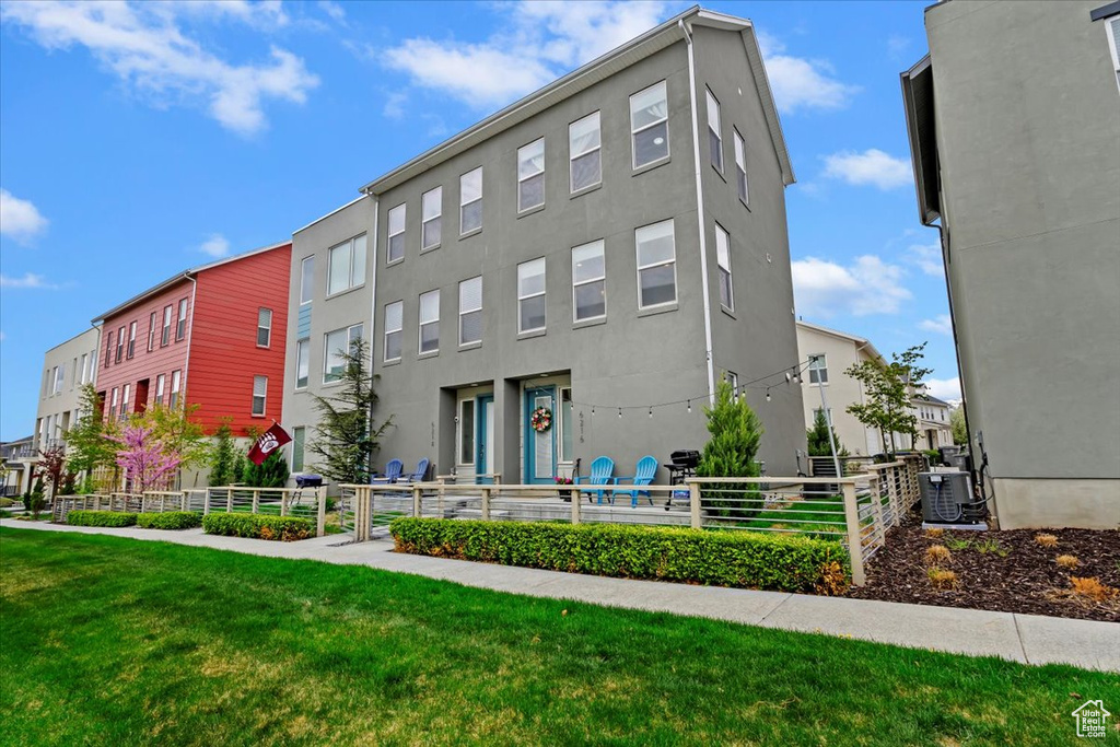View of building exterior with central air condition unit and fence