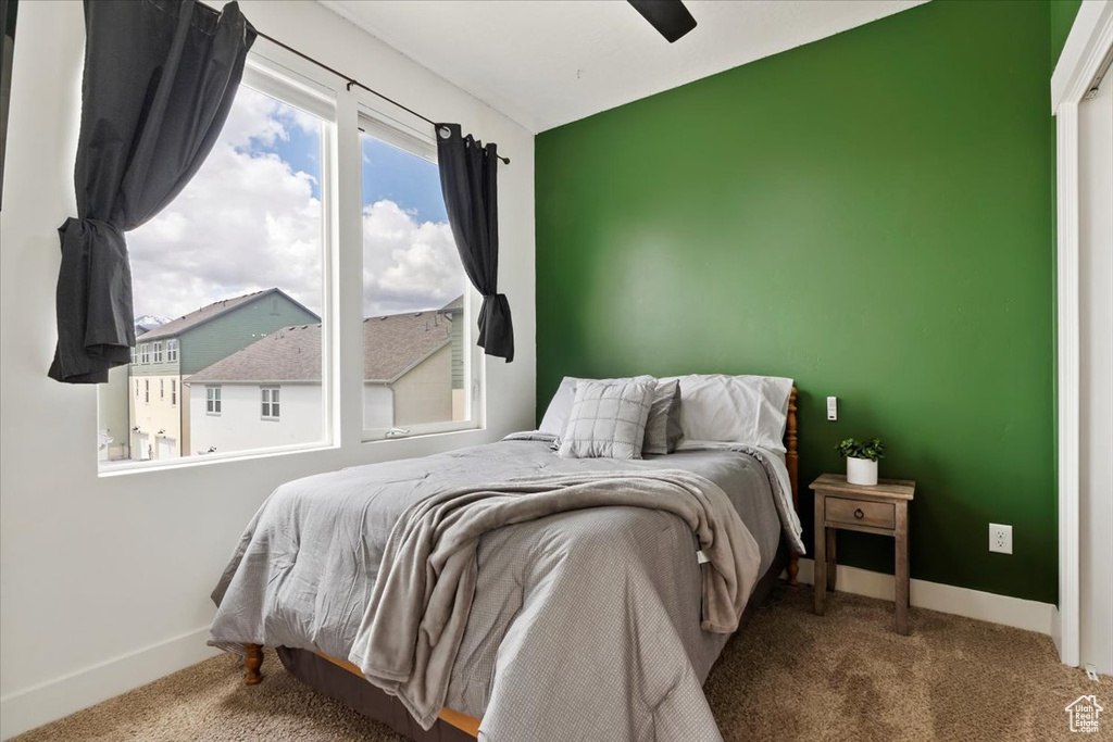 Bedroom featuring carpet floors, baseboards, and ceiling fan