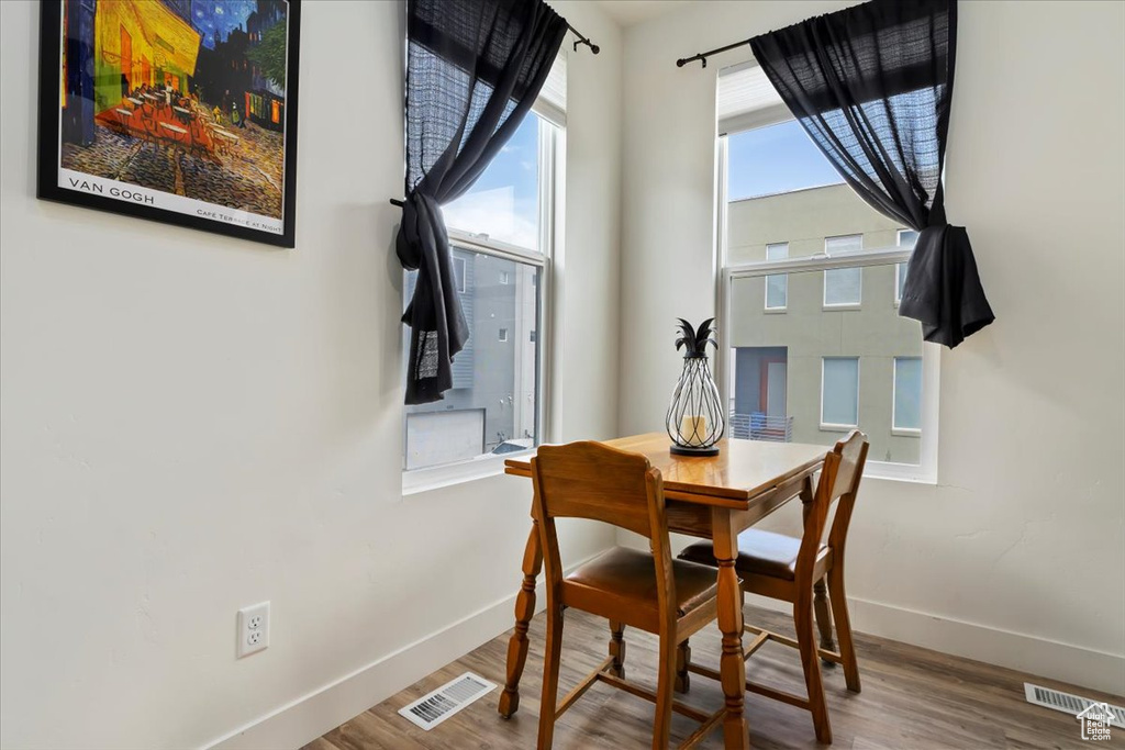 Dining space with baseboards, wood finished floors, and visible vents
