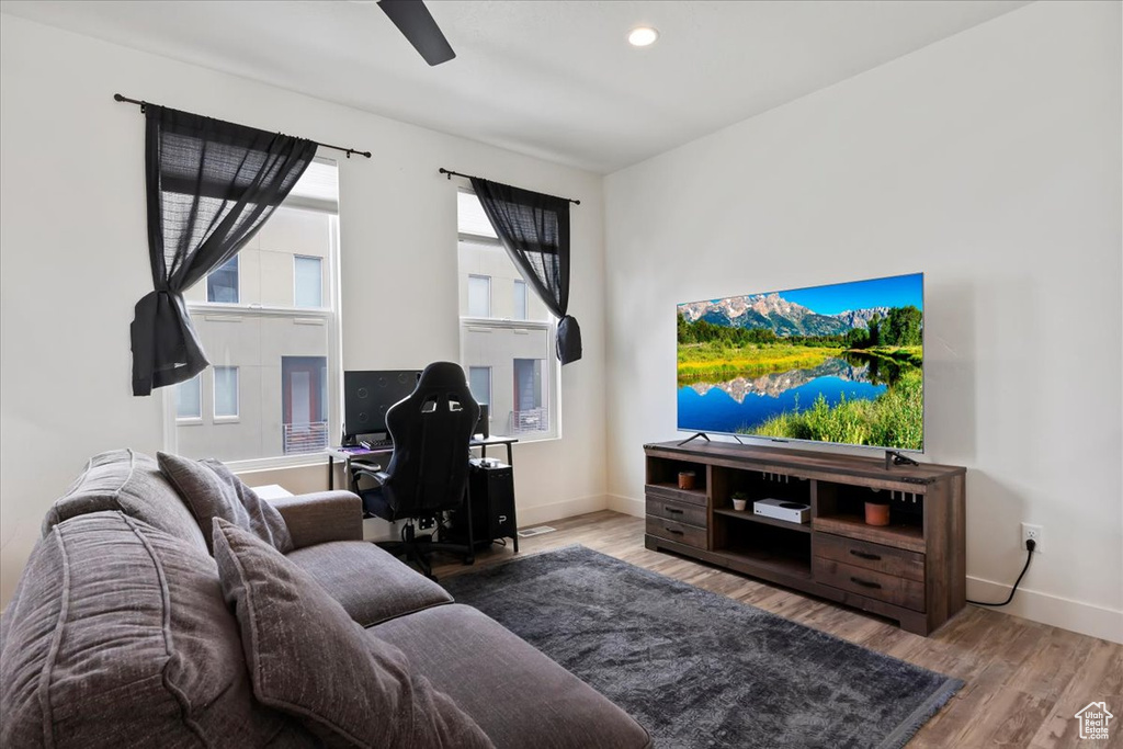 Living room featuring baseboards, ceiling fan, and wood finished floors