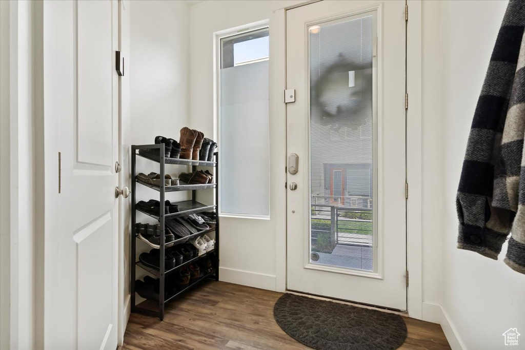 Doorway with baseboards and dark wood finished floors