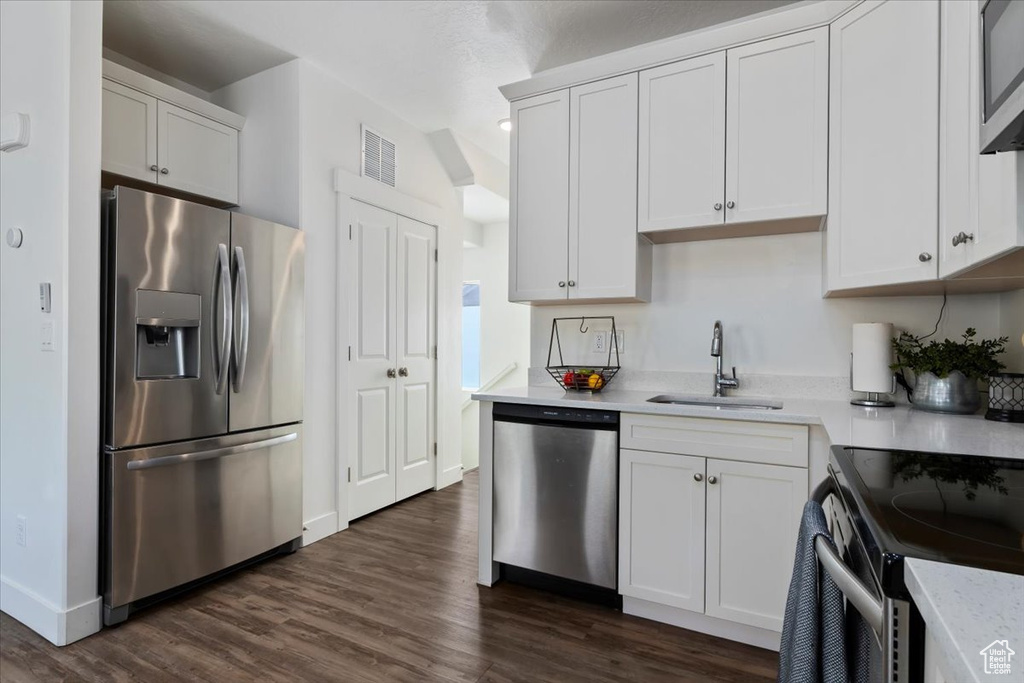 Kitchen featuring visible vents, a sink, dark wood-style flooring, and stainless steel appliances