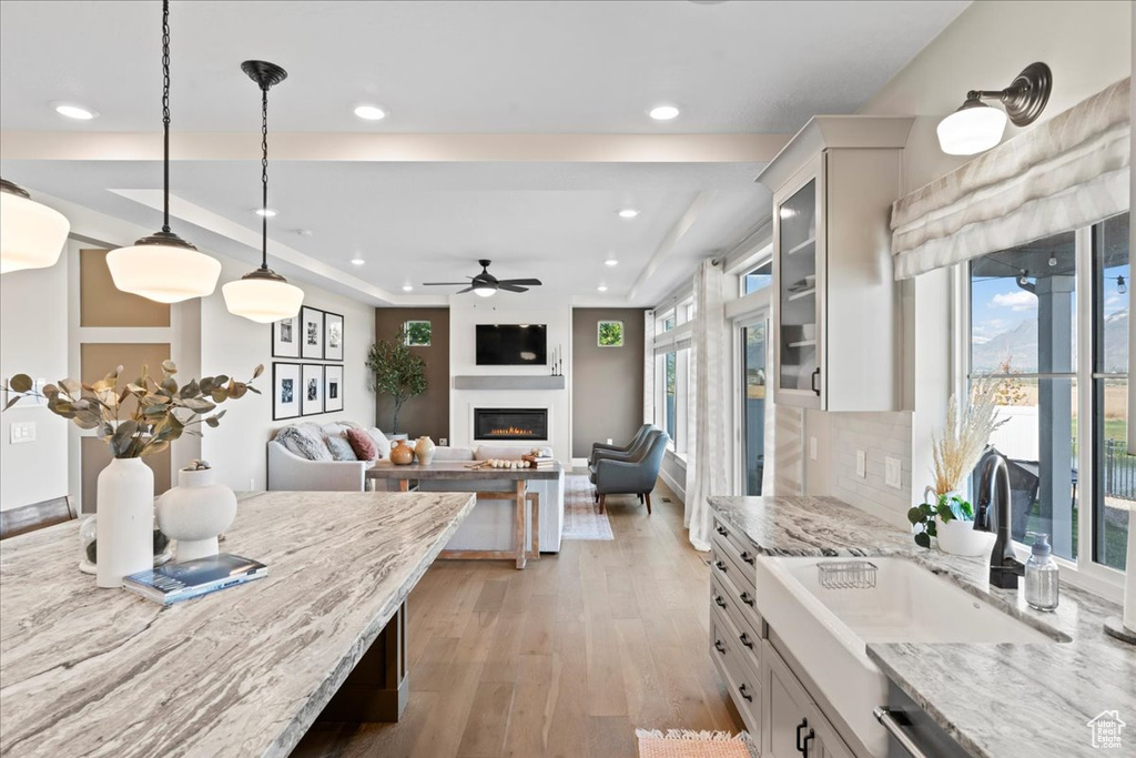 Kitchen featuring a sink, recessed lighting, a ceiling fan, and a glass covered fireplace