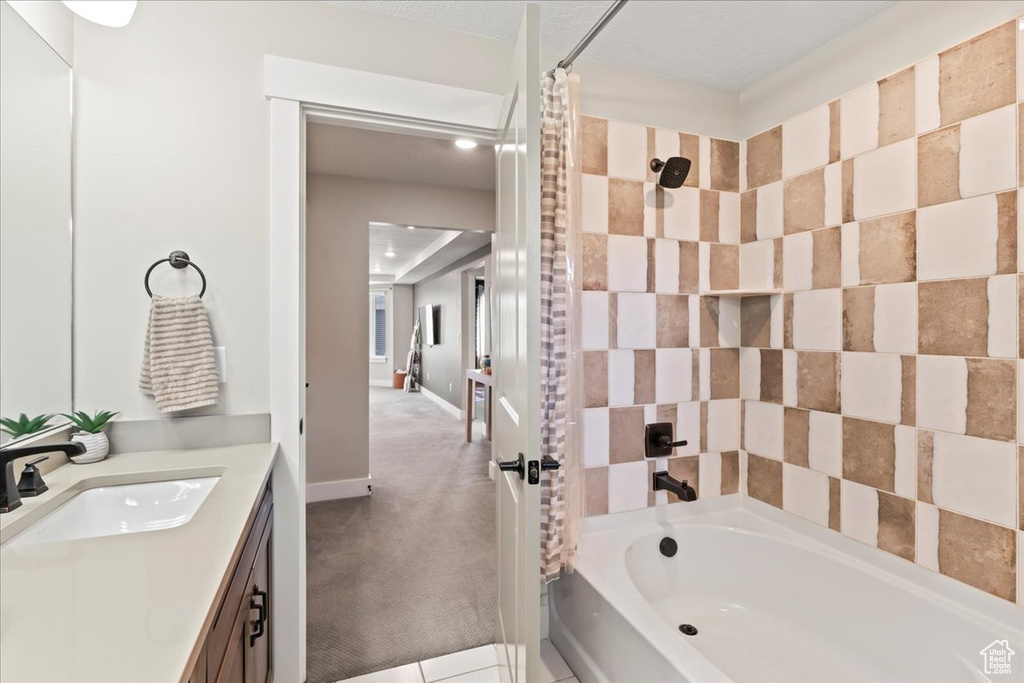 Bathroom with vanity, baseboards, and shower / tub combo