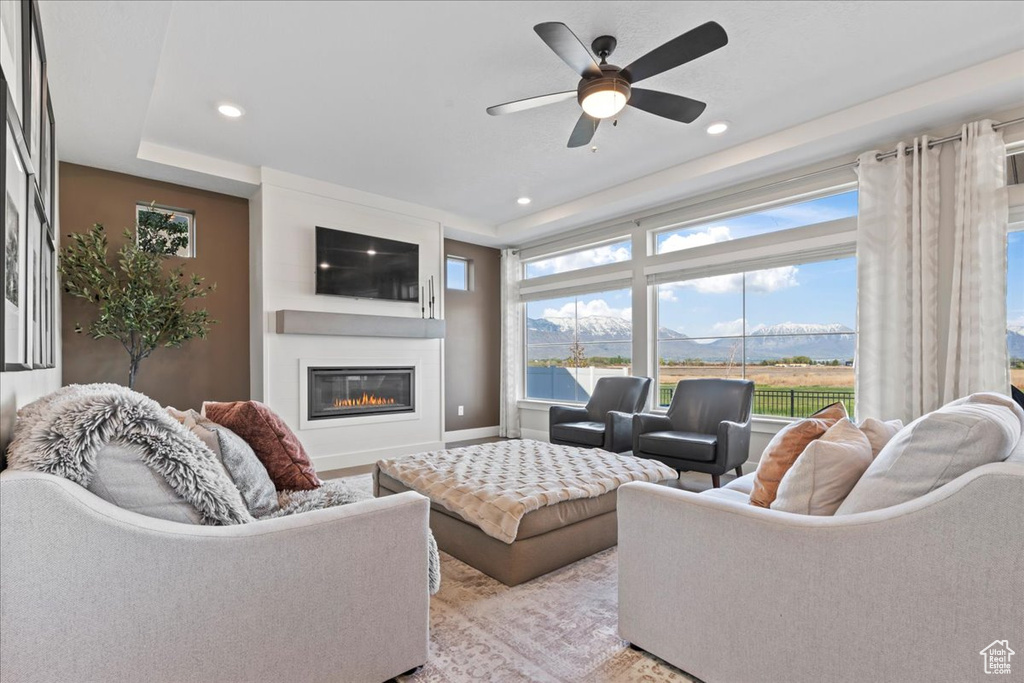 Living room with ceiling fan, light wood finished floors, a fireplace, recessed lighting, and baseboards