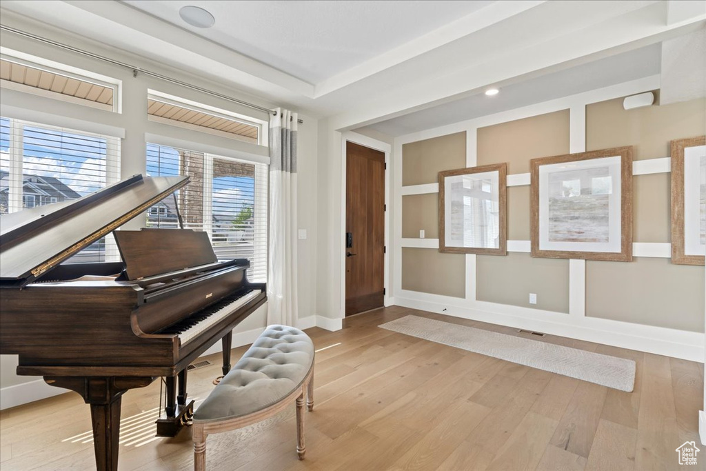 Living area with built in features, baseboards, wood finished floors, and visible vents