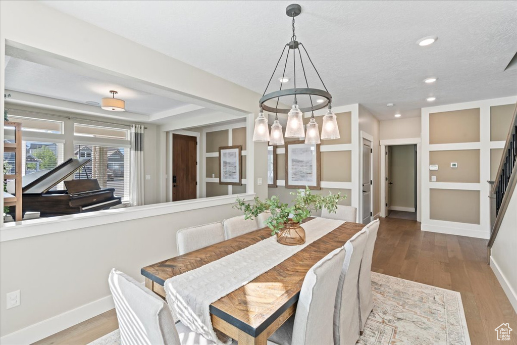 Dining space featuring baseboards, a textured ceiling, recessed lighting, and wood finished floors