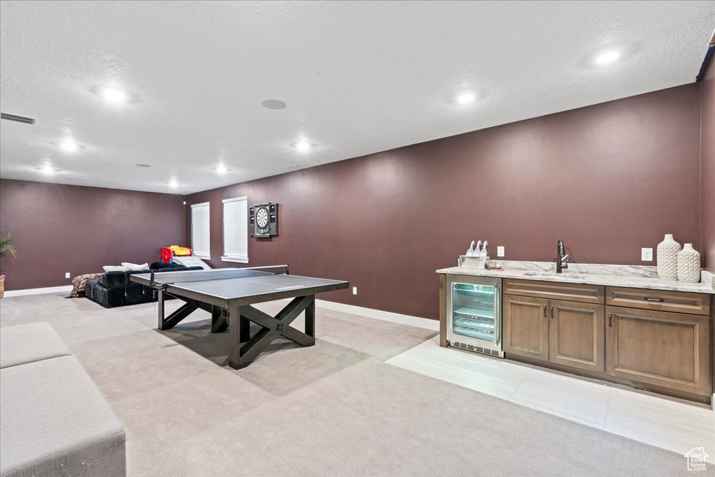 Playroom with visible vents, a sink, wine cooler, and light carpet