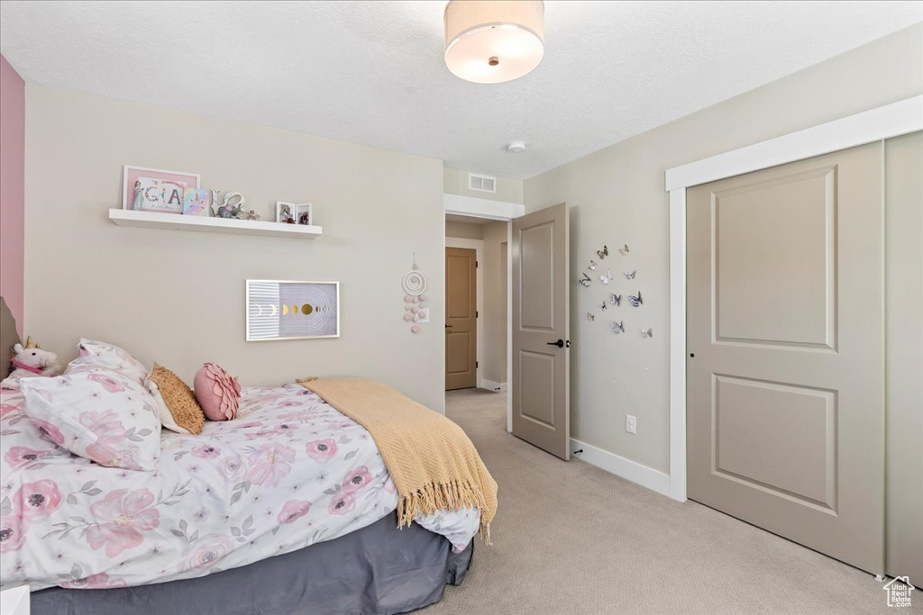 Bedroom featuring light colored carpet, baseboards, and visible vents