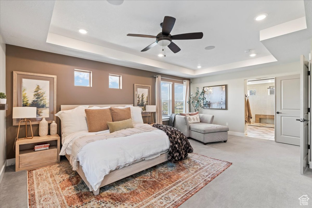 Bedroom featuring baseboards, recessed lighting, a tray ceiling, and light carpet