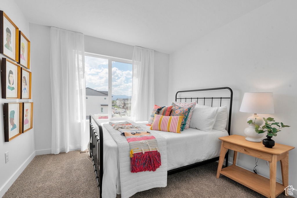 Bedroom with light colored carpet and baseboards