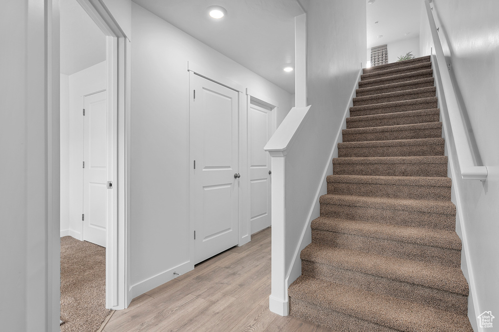 Stairs with recessed lighting, baseboards, and wood finished floors