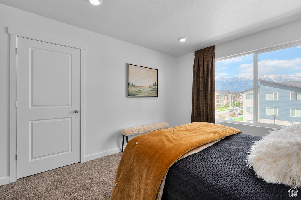 Carpeted bedroom featuring baseboards, recessed lighting, and a mountain view