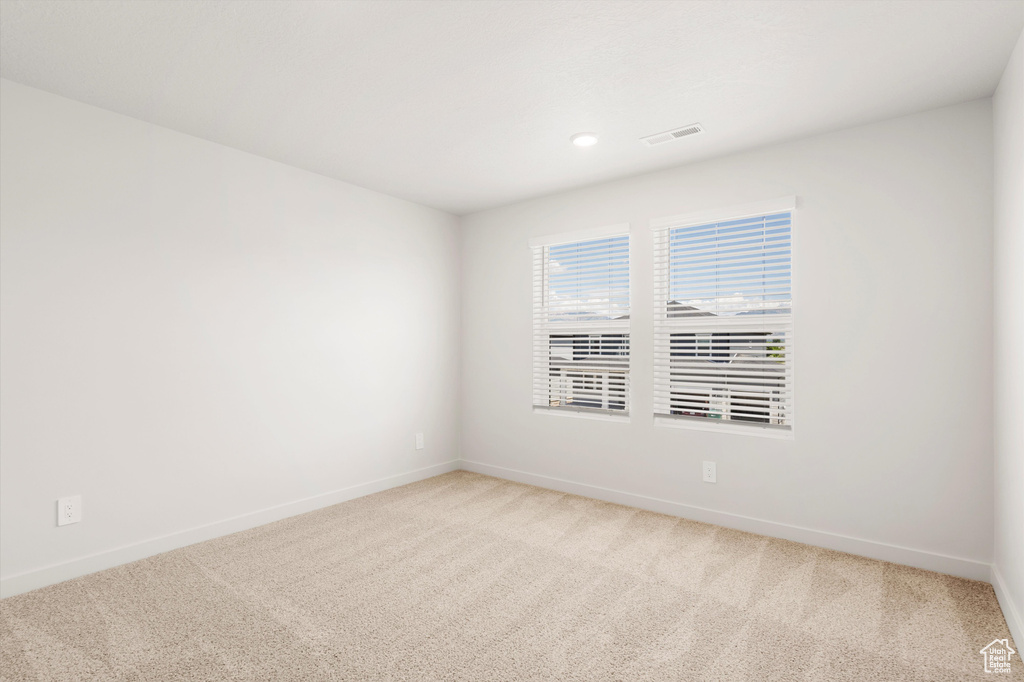 Unfurnished room featuring light colored carpet, baseboards, and recessed lighting