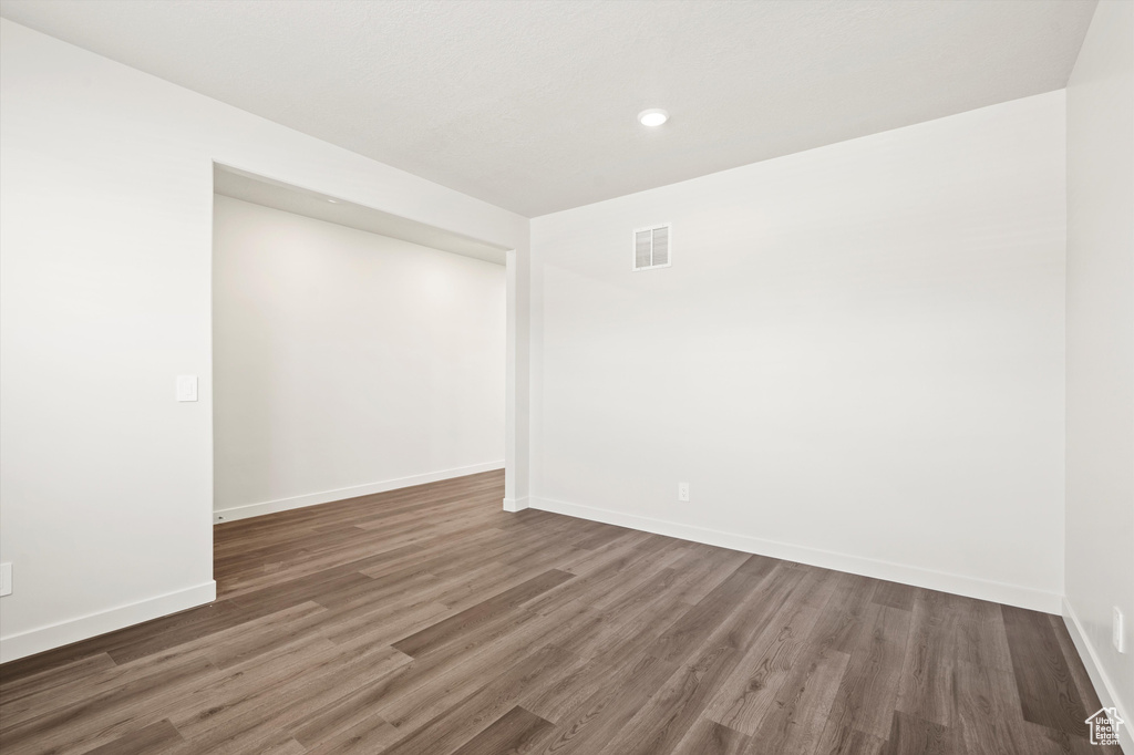 Spare room featuring wood finished floors, baseboards, and recessed lighting