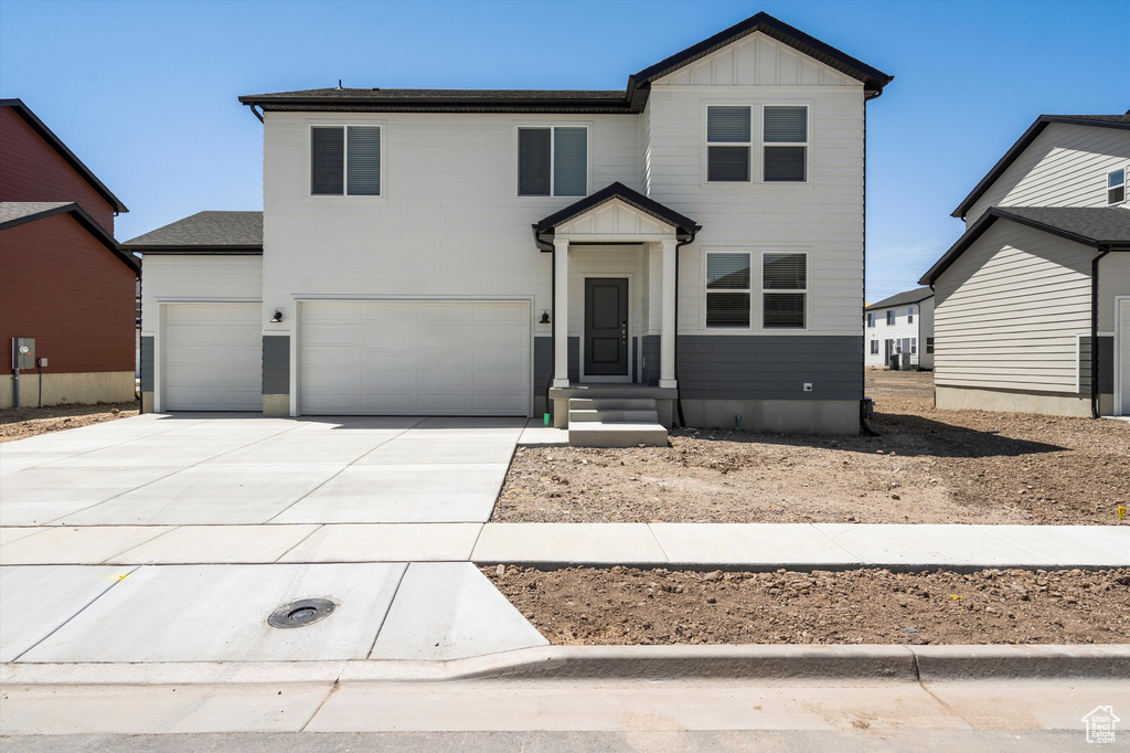 View of front of property with driveway, board and batten siding, and a garage