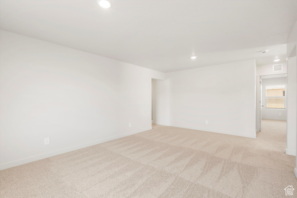 Empty room featuring light colored carpet, recessed lighting, and baseboards