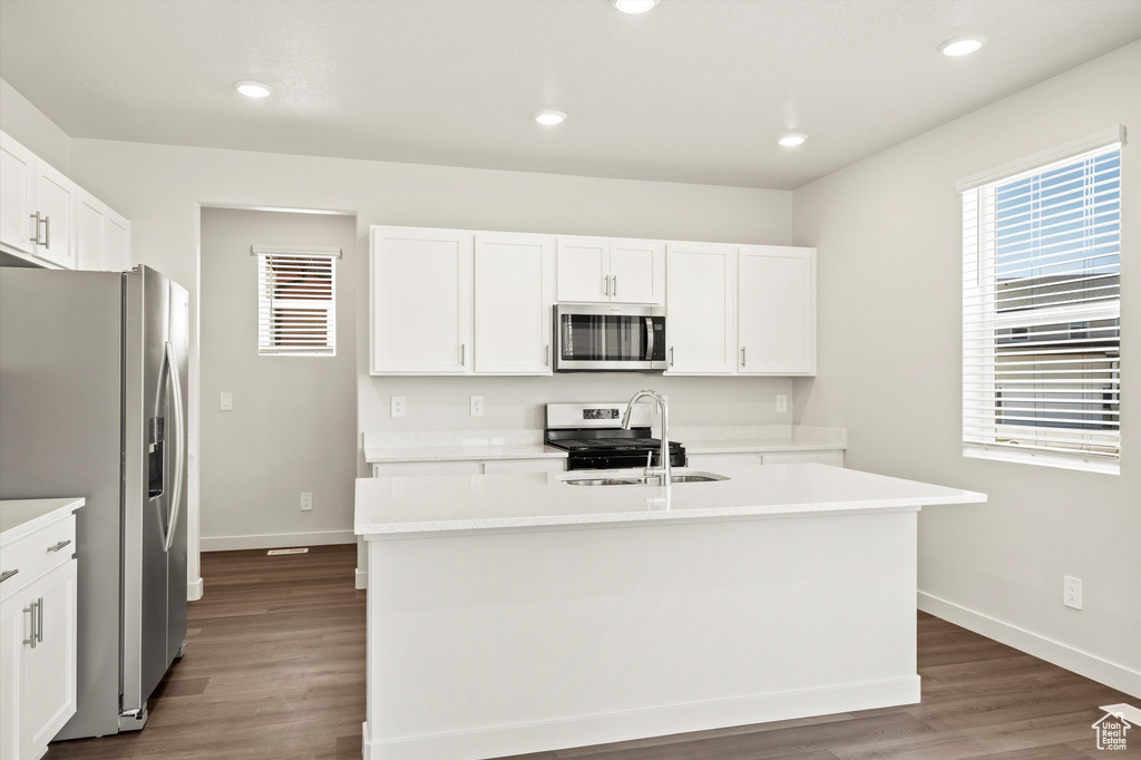 Kitchen featuring appliances with stainless steel finishes, a sink, baseboards, light countertops, and recessed lighting