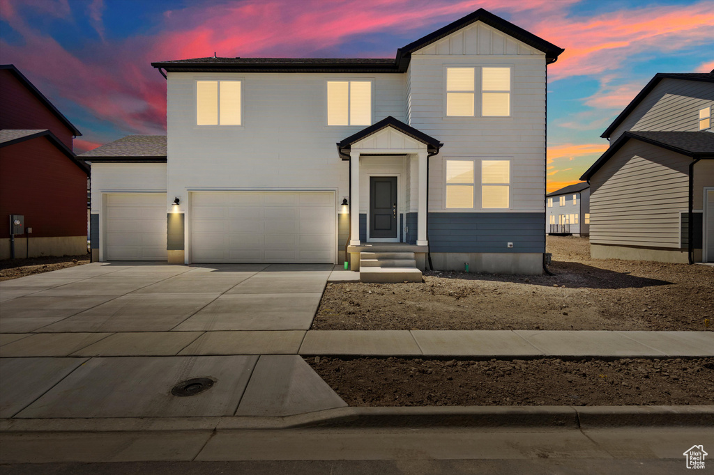 View of front of home featuring driveway, board and batten siding, and an attached garage