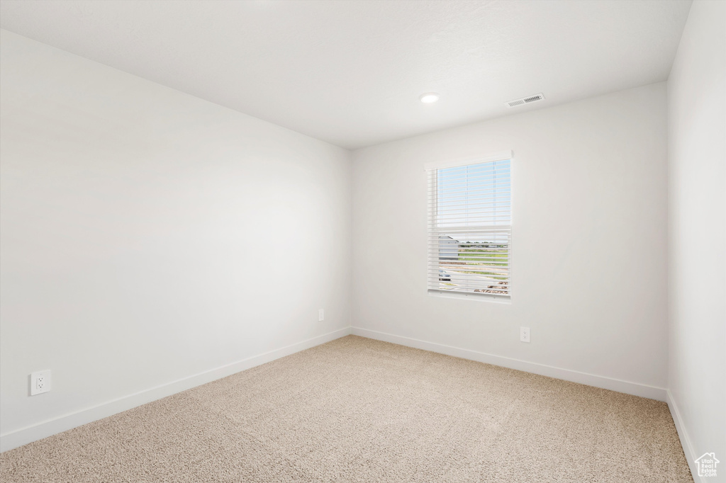 Unfurnished room featuring light colored carpet, baseboards, and recessed lighting