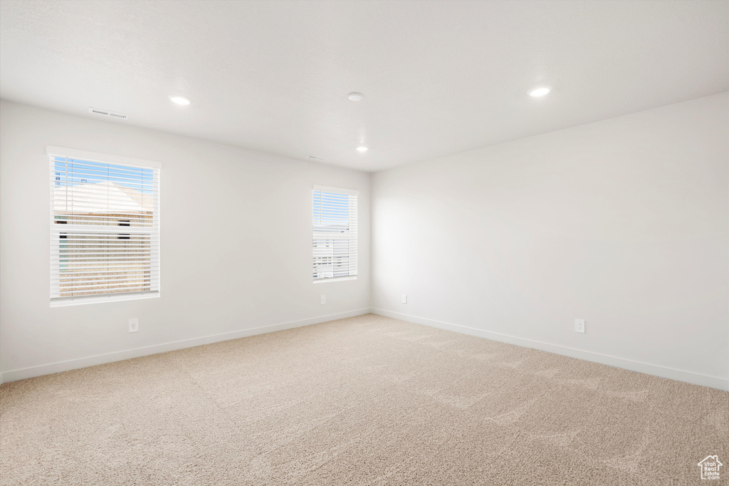 Unfurnished room featuring light carpet, baseboards, and recessed lighting