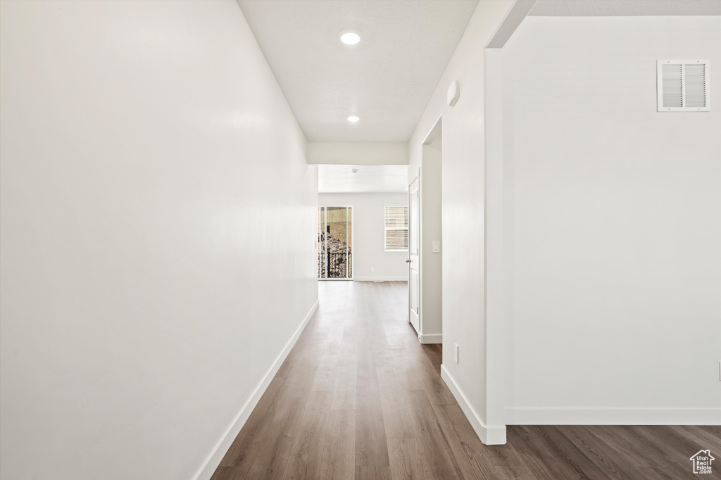 Hallway with wood finished floors, baseboards, and recessed lighting