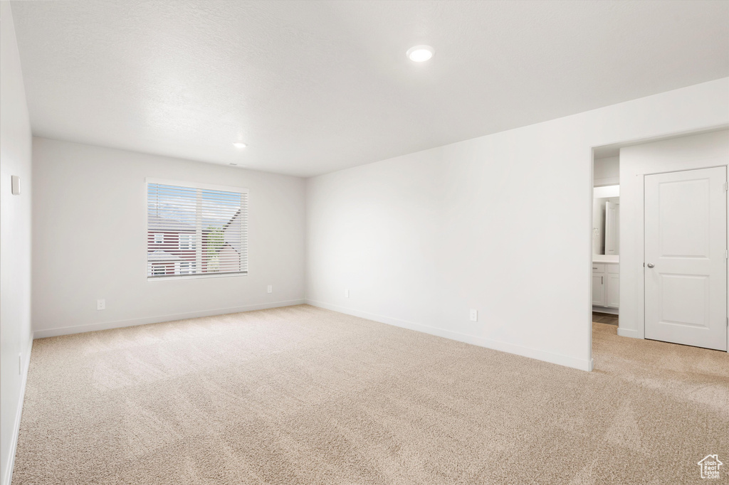 Spare room featuring light carpet, baseboards, and recessed lighting