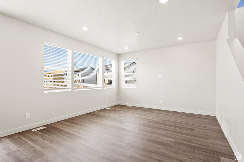 Spare room featuring wood finished floors, baseboards, and recessed lighting