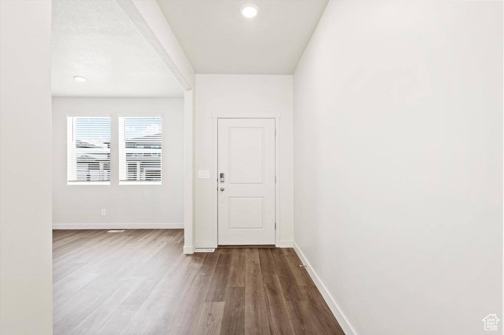 Foyer entrance with wood finished floors and baseboards