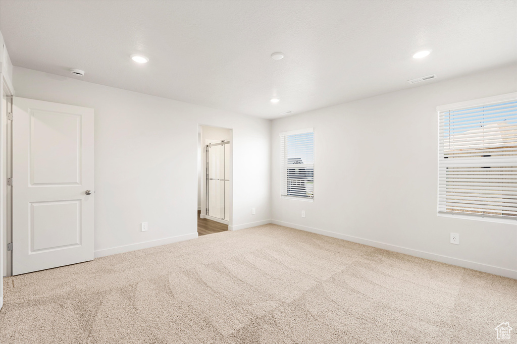 Unfurnished bedroom featuring carpet, baseboards, multiple windows, and recessed lighting