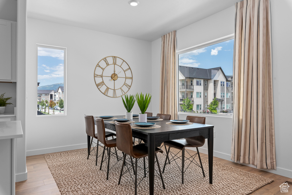 Dining space featuring light wood-type flooring, baseboards, and visible vents