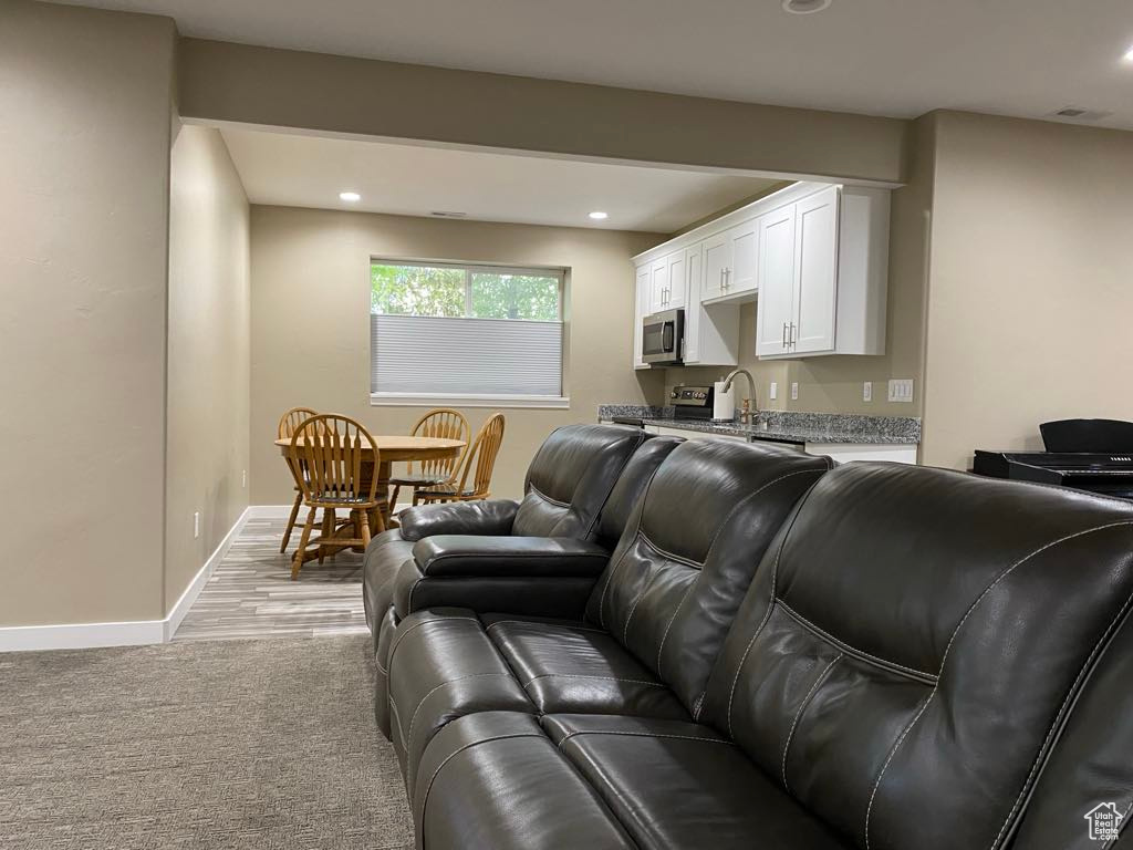 Living room with recessed lighting, baseboards, and light carpet